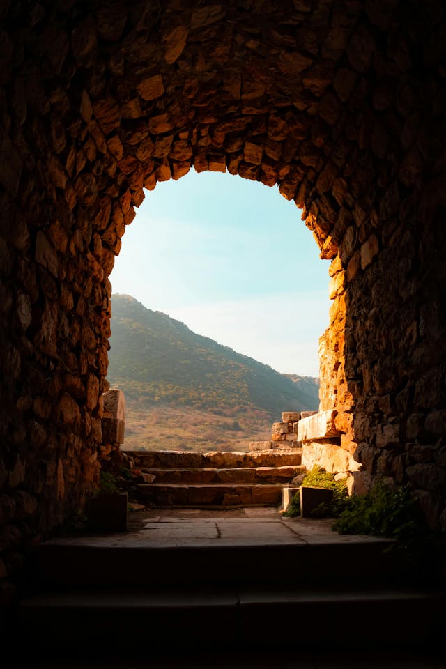 Arched Stone Passageway to a Scenic Mountain View
